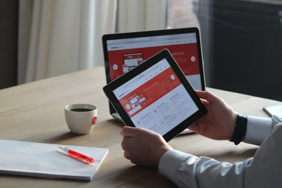 Vue rapprochée d’un smartphone affichant une image floue, posé sur un bureau à côté d’un ordinateur portable.